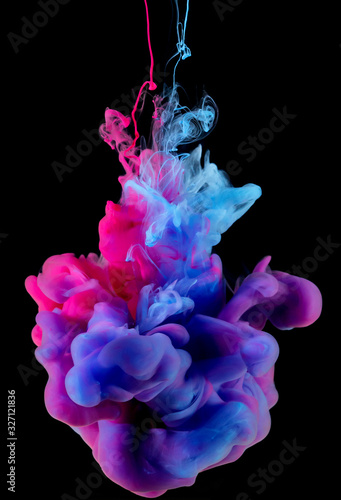 Colors ink splashing in water isolated on black background.
