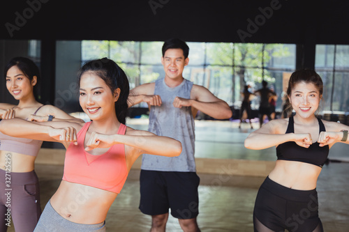 Fototapeta Naklejka Na Ścianę i Meble -  A group of young beautiful Asian women exercise in the fitness gym by dancing.Athletes who maintain health Exercise by cardio in class