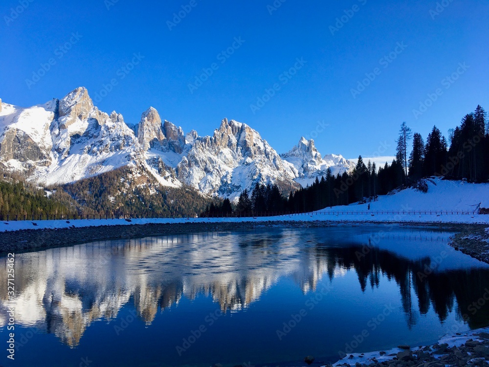 San Martino di Castrozza. Montagne innevate riflesse nel lago. Paesaggio di montagna. Dolomiti