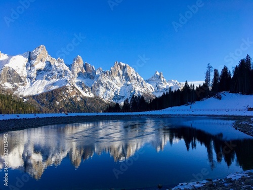 San Martino di Castrozza. Montagne innevate riflesse nel lago. Paesaggio di montagna. Dolomiti