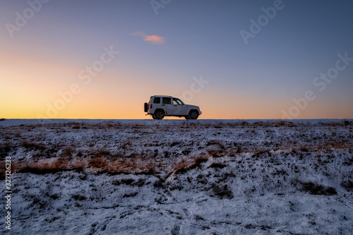 car on the road at dawn in winter in Iceland