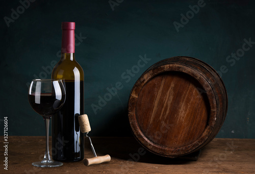 Expensive wine bottles collection and wooden barrel in the cellar, wine tasting and production concept