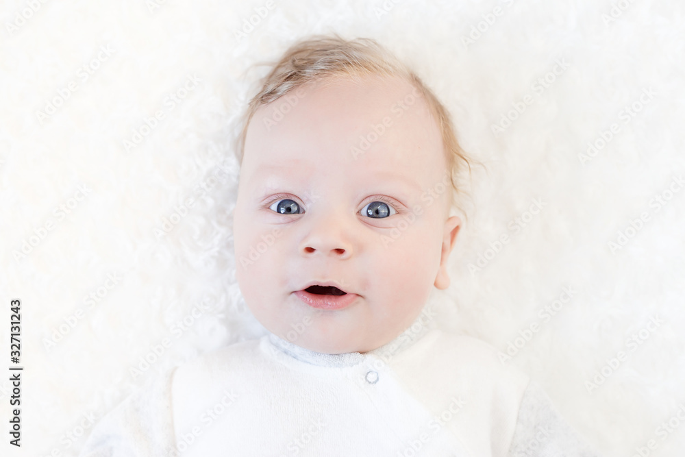 Cute beautiful baby with big eyes lies on the bed Cute beautiful baby with big eyes lies on the bed