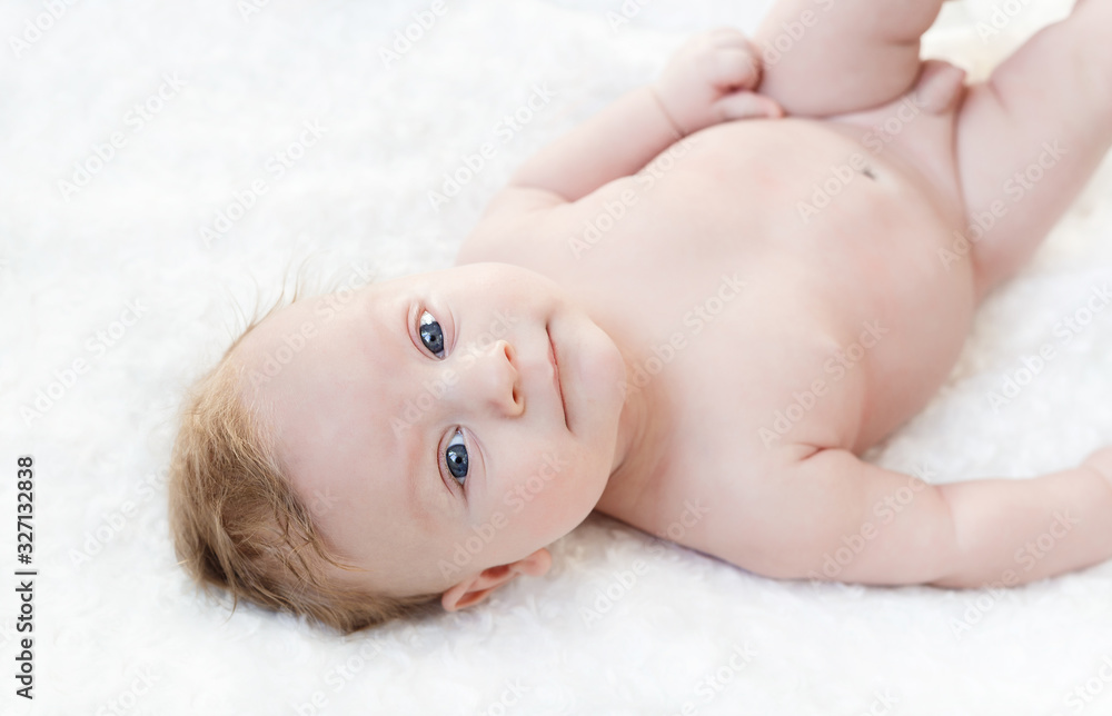 four month old white boy with blue eyes lying on a white background