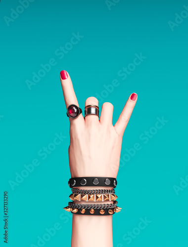 Fotografie Rock hand sign, female hand punk rock gesture with gold wrist bracelets and fing