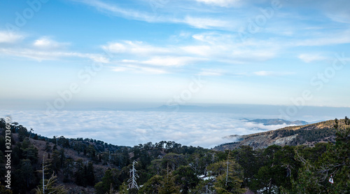 View of the blue fog over a mountain valley in clear sunny weather from the top of the mountain.