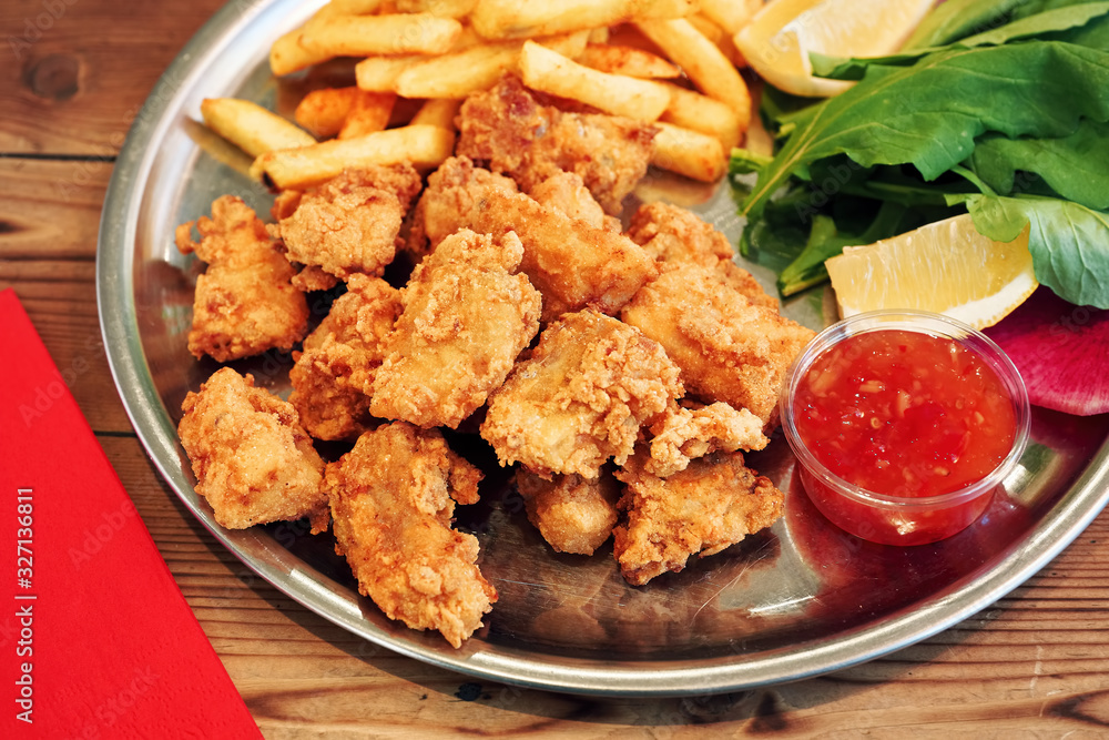 Deep fried mussels in a plate served with sauce and french fries