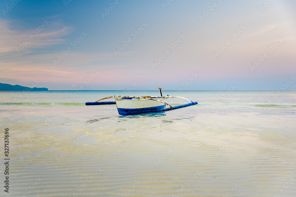 Small boat at the shore of Boracay, Philippines during early morning low tide Small boat at the shore of Boracay, Philippines during early morning low tide