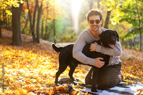 guy with dog labrodor in autumn park at sunset photo