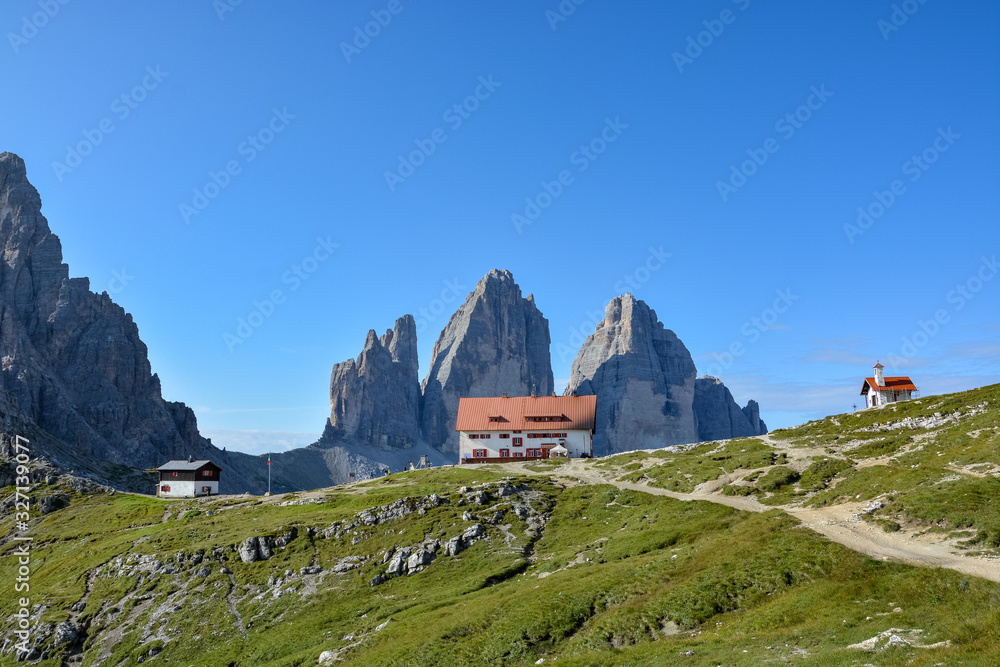 Famous mountains Three Peaks in the Dolomites with the alpine hut Dreizinnenhuette  in the front