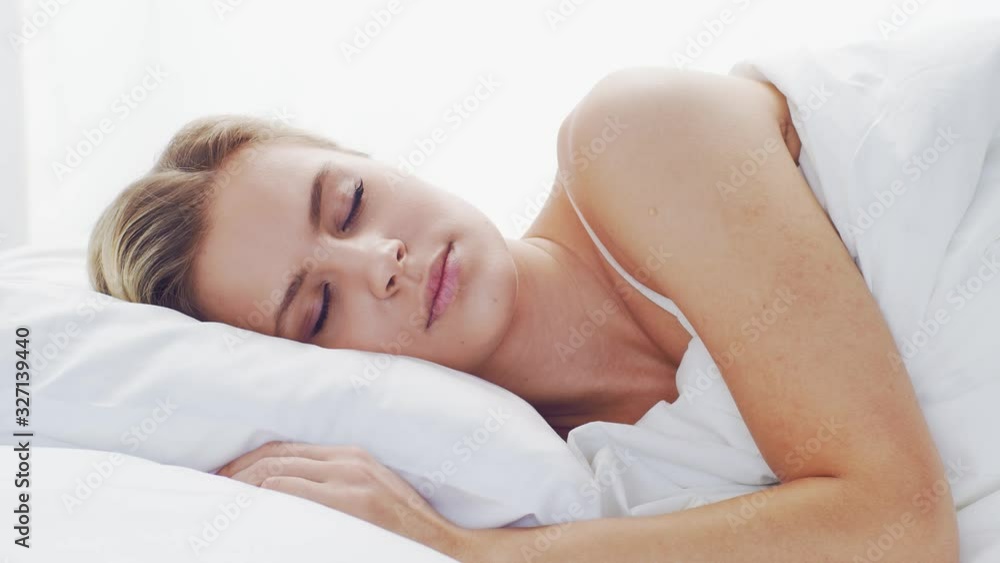Young woman lying in the bed. Beautiful blond sleeping girl. Morning in the bedroom. Health and rest concept. Young woman lying in the bed. Beautiful blond sleeping girl. Morning in the bedroom. Health and rest concept.