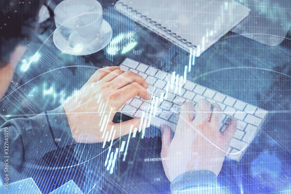 Double exposure of graph with man typing on computer in office on background. Concept of hard work. Double exposure of graph with man typing on computer in office on background. Concept of hard work.