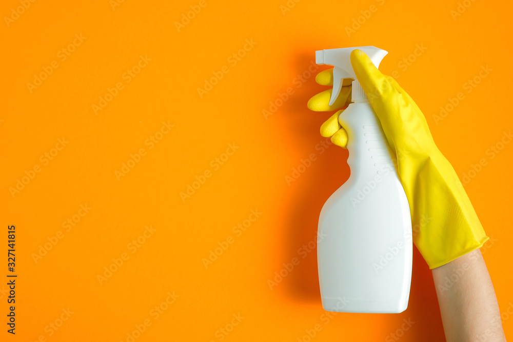 Hand in yellow rubber glove holding plastic spray bottle with cleaning ...