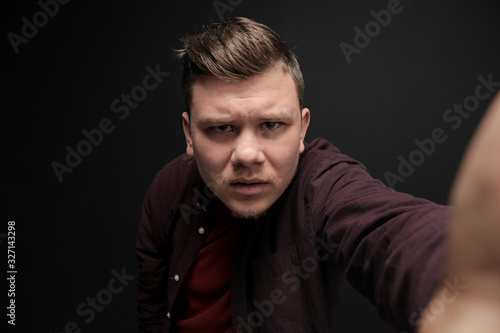 Portrait of young puzzled man isolated on gray background
