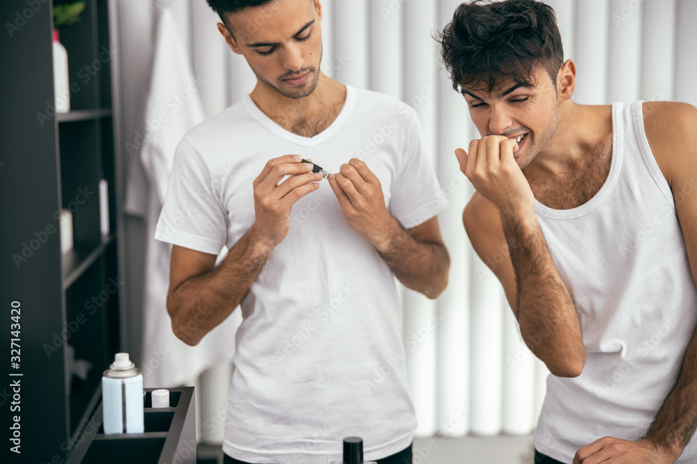 Obraz premium Brothers in white t-shirts doing morning routine at home