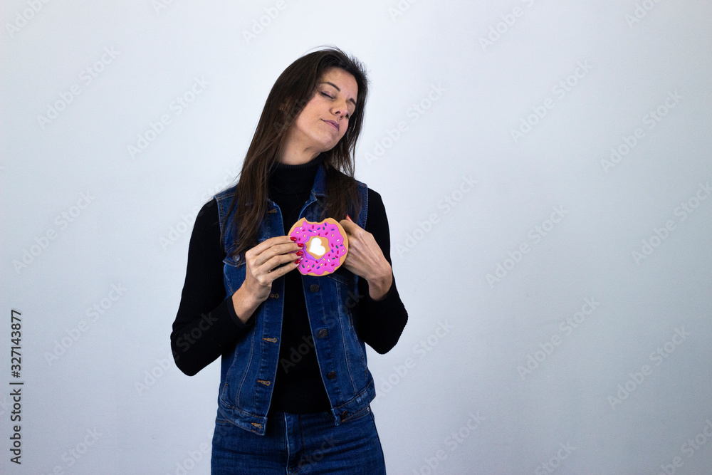 Portrait of attractive caucasian middle age womancookie with closed eyes, keeps hands on chest, isolated on gray background studio shotblack sweater, denim jacket, jeans, dark air. Place for your text Portrait of attractive caucasian middle age womancookie with closed eyes, keeps hands on chest, isolated on gray background studio shotblack sweater, denim jacket, jeans, dark air. Place for your text