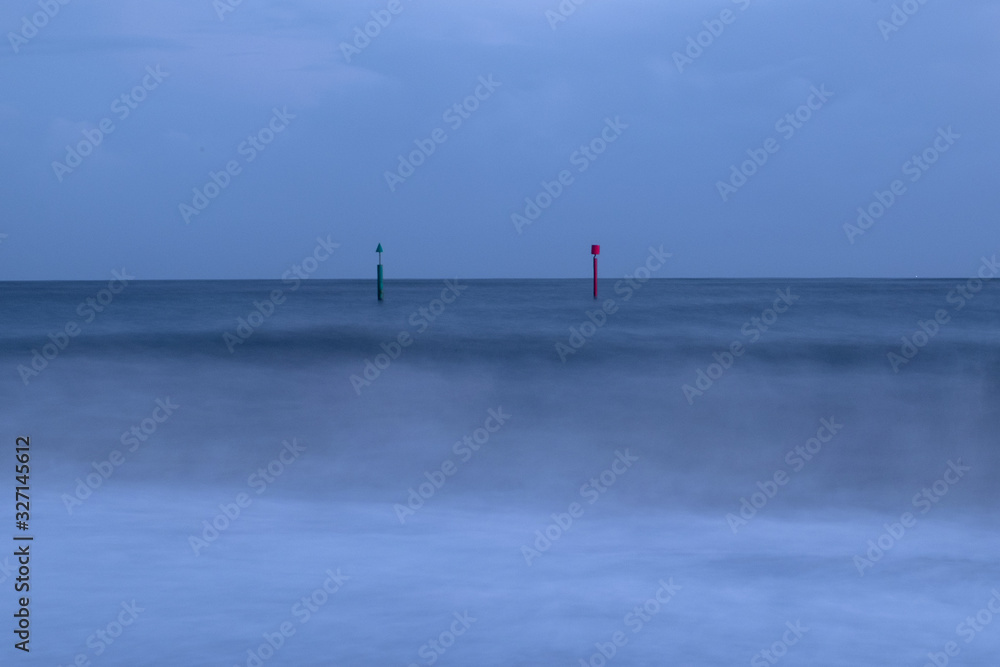 Gren and red posts in the sea