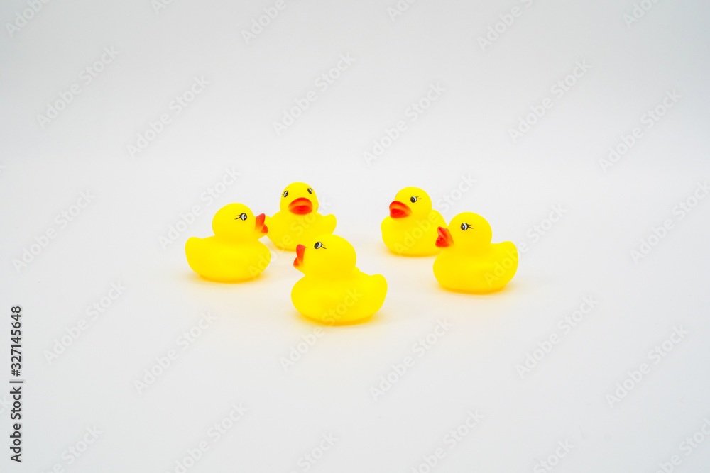 Five mini yellow rubber ducks in circle facing each other. Isola Five mini yellow rubber ducks in circle facing each other. Isola