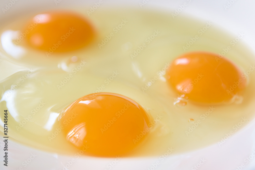 Three fresh eggs crushed on a white plate Three fresh eggs crushed on a white plate