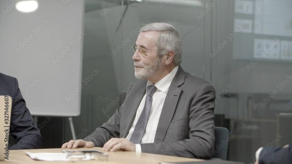 Thoughtful team leader communicating with colleagues in room. Group of office employees sitting at table and discussing new business plan. Business, teamwork concept Thoughtful team leader communicating with colleagues in room. Group of office employees sitting at table and discussing new business plan. Business, teamwork concept