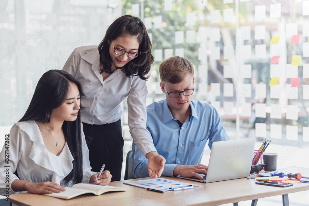 Obraz premium Group of young asian modern people in smart casual wear talking and smiling during the meeting in office.