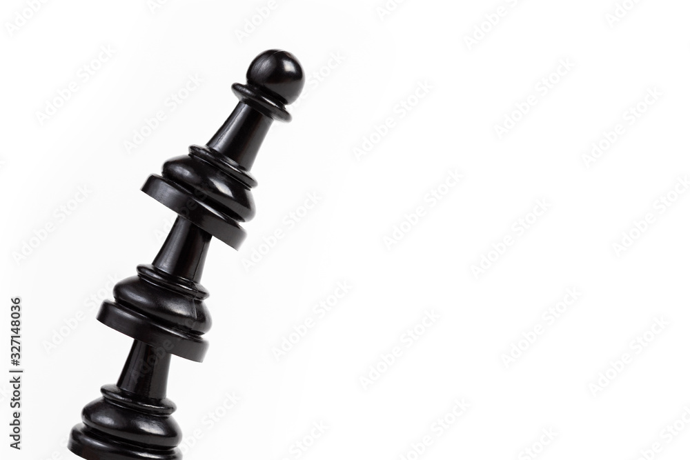 Simple leaning tower made of chess pawn pieces, curved bent construct of black game pieces placed on top of each other. Unstable shaky construction about to fall over / aiming high together concept Simple leaning tower made of chess pawn pieces, curved bent construct of black game pieces placed on top of each other. Unstable shaky construction about to fall over / aiming high together concept