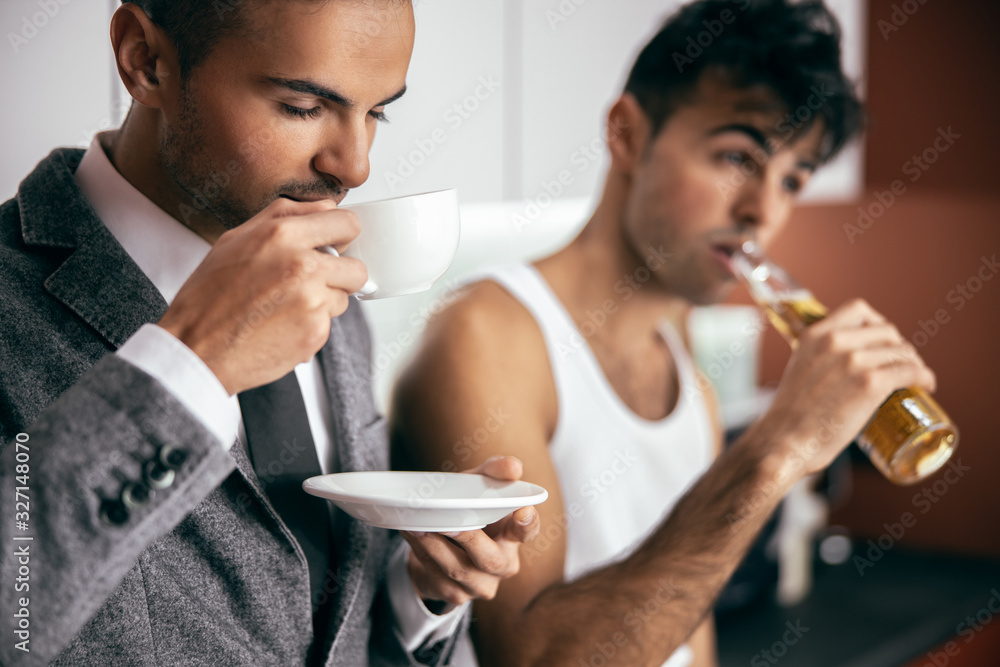 Male twins staying together in the kitchen in the morning Male twins staying together in the kitchen in the morning