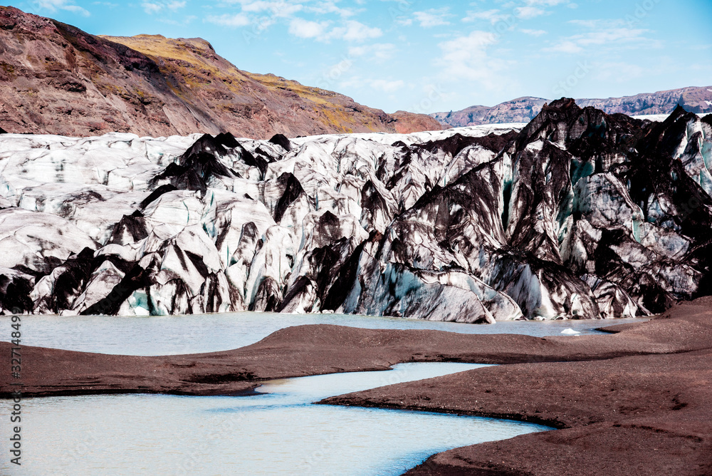 Charming beautiful scenery with glacier in volcanic soot in Solheimajokull lagune, Iceland. Exotic countries. Amazing places. Popular tourist atraction. (global warming – concept)