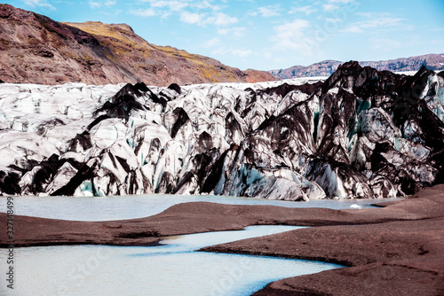 Obraz na płótnie Charming beautiful scenery with glacier in volcanic soot in Solheimajokull lagune, Iceland. Exotic countries. Amazing places. Popular tourist atraction. (global warming – concept) w salonie