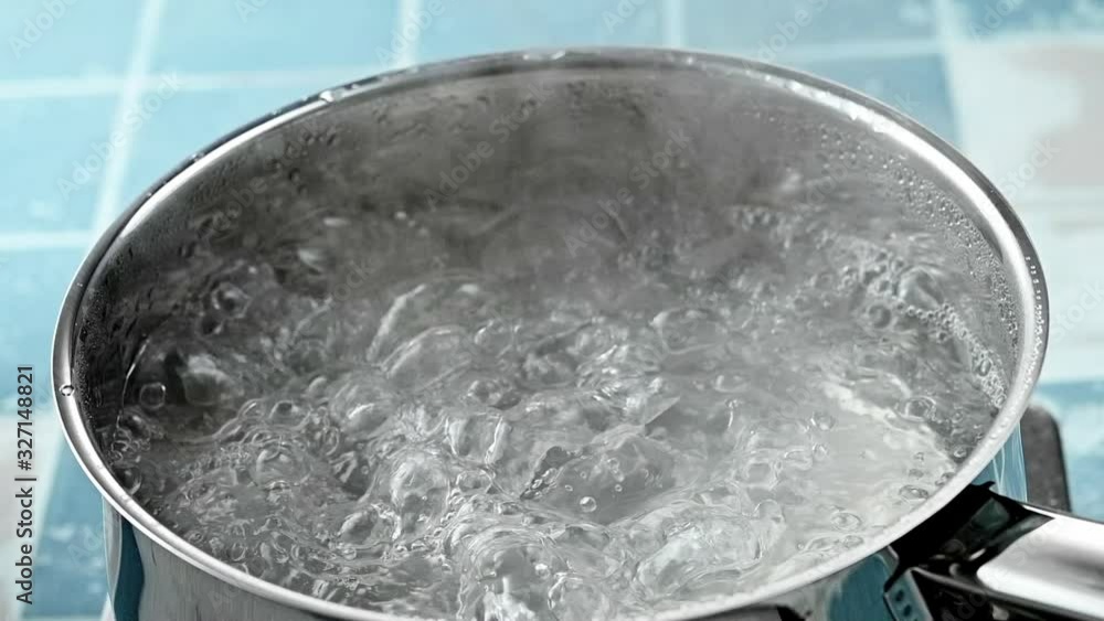 The pan of boiling clean water in close-up on the stove, after removing the lid The pan of boiling clean water in close-up on the stove, after removing the lid