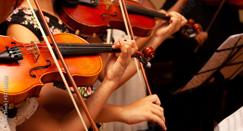 Obraz na plátně Row, group of anonymous violin players, children, people playing, bows in hands, stands in front, closeup