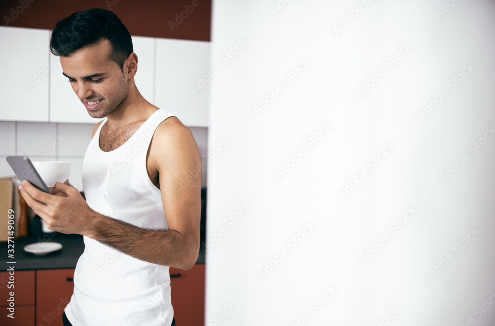 Happy handsome male in white t-shirt standing with coffee