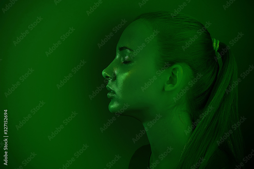 Young beautiful girl posing in a Studio with creative lighting. Artistic design, green tinting