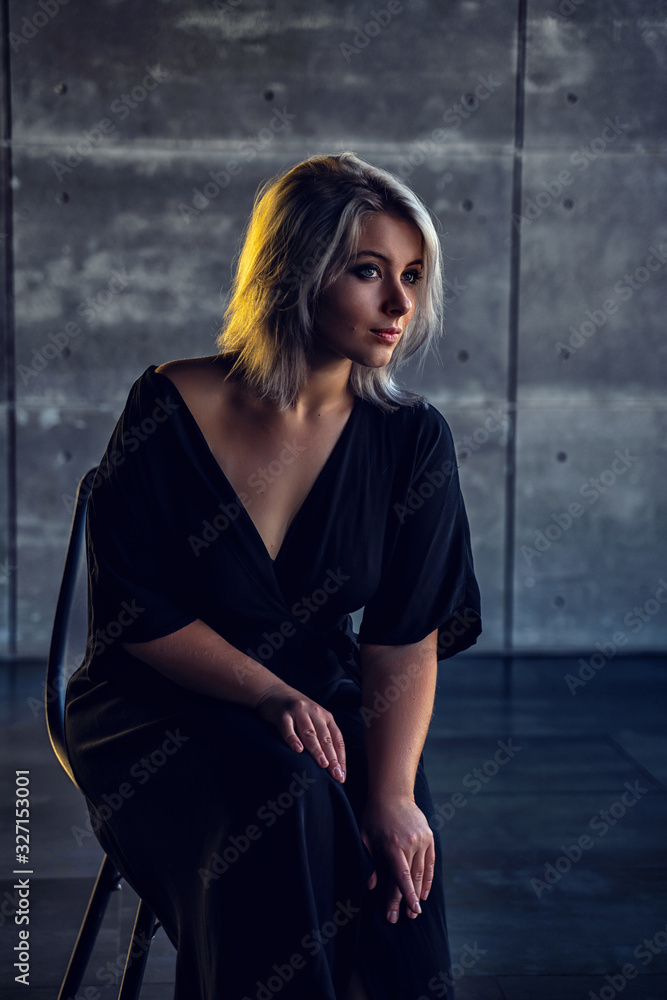 girl in a black dress dressing gown sitting in a house in a dark interior