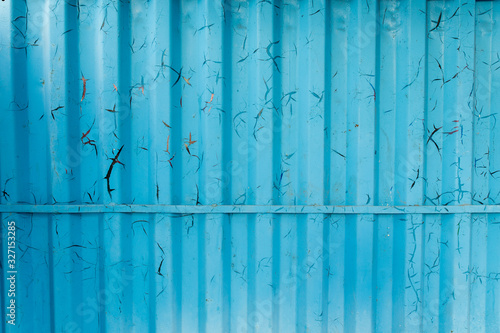 Metal curly sheets are painted in sky-blue color, old cracked paint. Abstract grunge texture.