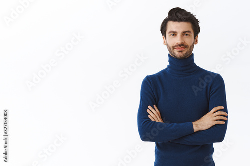 Confident good-looking male entrepreneur in blue high neck sweater, cross arms over chest, smirk sassy and self-assured, standing assertive. Handsome macho man dressed-up for christmas party