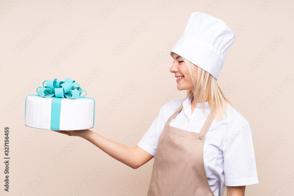 Young Russian woman with a big cake over isolated background with happy expression Young Russian woman with a big cake over isolated background with happy expression