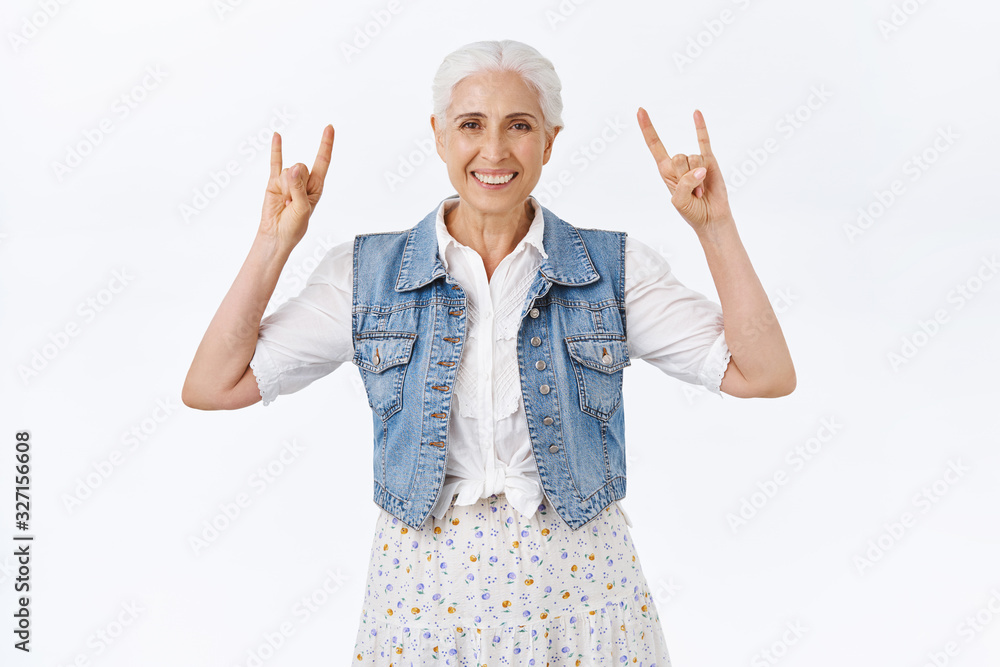 Joyful modern, stylish cool granny, having fun with grandkids listening rock-n-roll music telling good old days at heavy metal concerts, showing rock signs and smiling carefree, white background Joyful modern, stylish cool granny, having fun with grandkids listening rock-n-roll music telling good old days at heavy metal concerts, showing rock signs and smiling carefree, white background