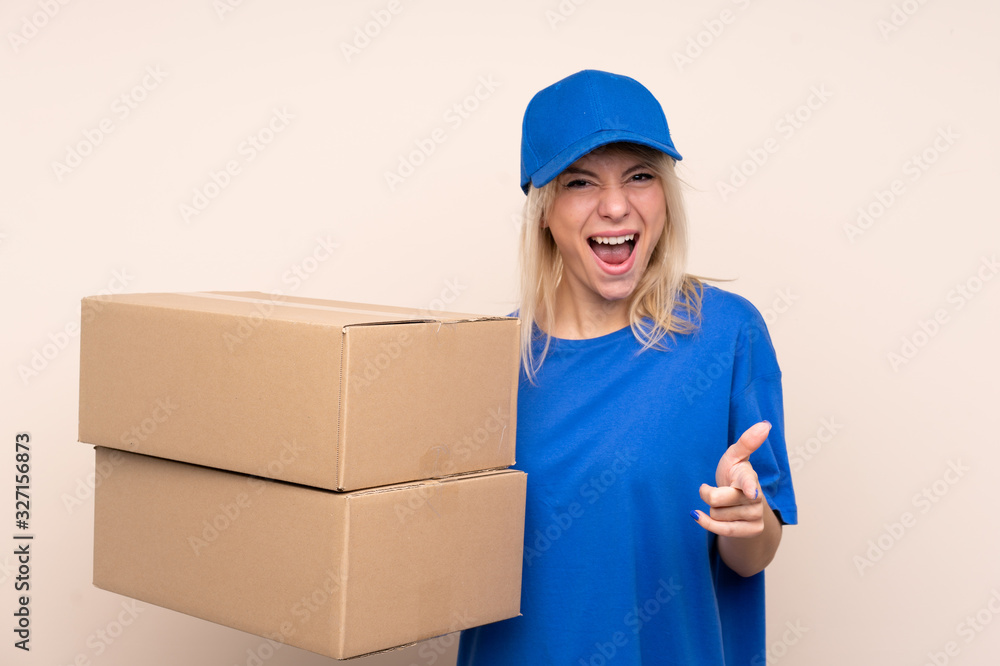 Young delivery woman over isolated background points finger at you Young delivery woman over isolated background points finger at you