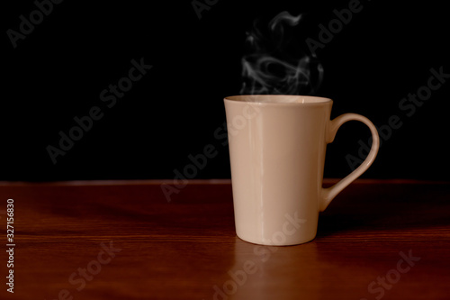 Coffee in a white cup on the table and dark background