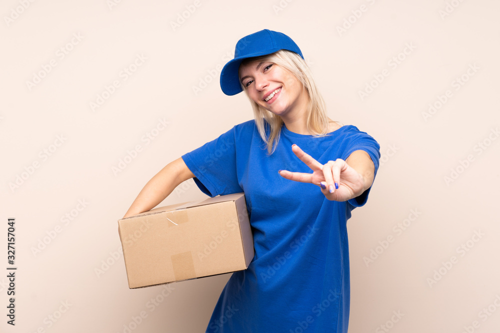 Young delivery woman over isolated background smiling and showing victory sign Young delivery woman over isolated background smiling and showing victory sign