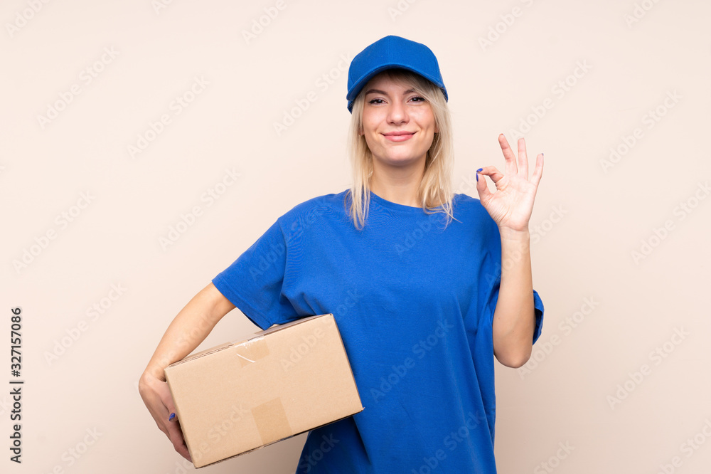 Young delivery woman over isolated background showing an ok sign with fingers Young delivery woman over isolated background showing an ok sign with fingers