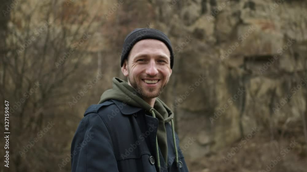 Stylish Young Guy Standing In Nature. Behind Him Is Rock. Guy Is Smiling. Stylish Young Guy Standing In Nature. Behind Him Is Rock. Guy Is Smiling.