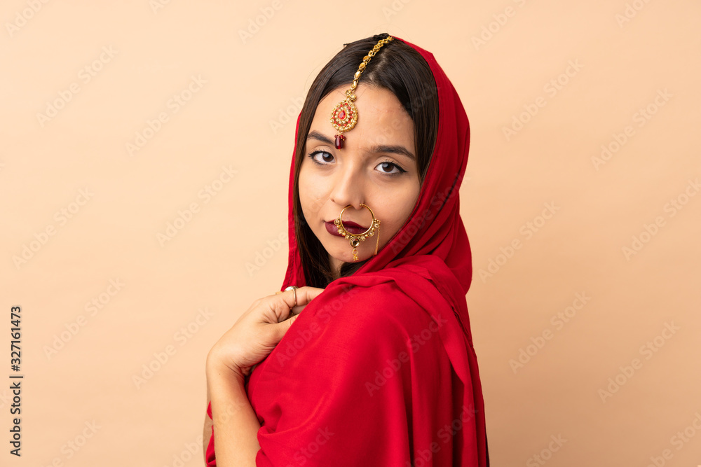 Young Indian woman isolated on beige background Young Indian woman isolated on beige background