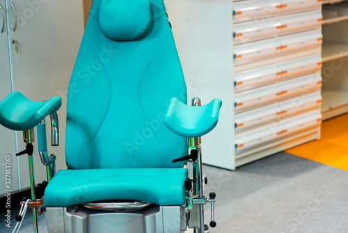 Blue gynecological chair in medical office in clinic. Modern interior in the gynecologist's office.