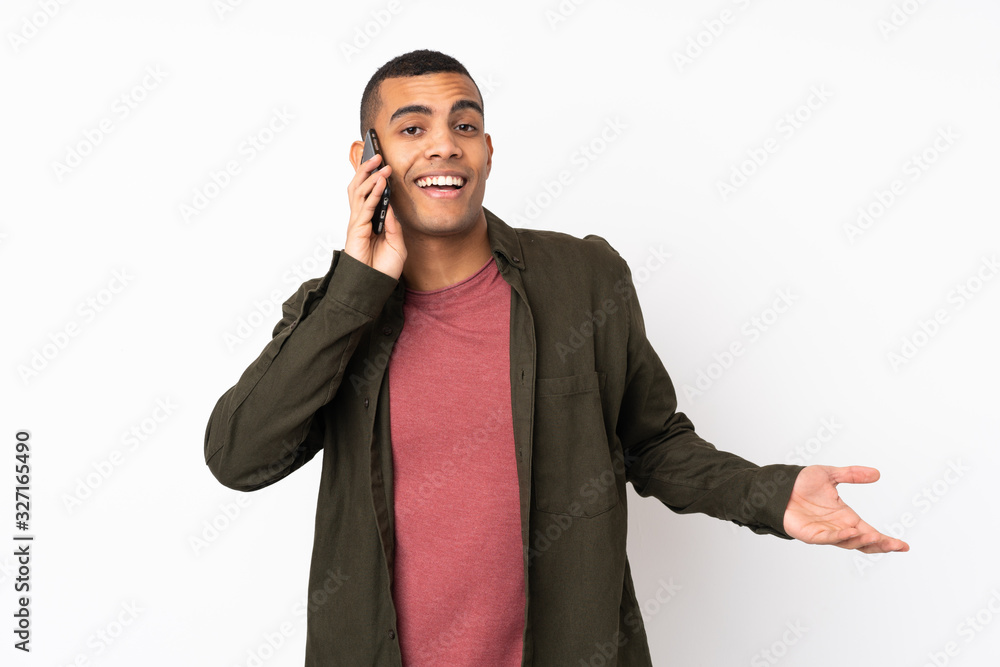 Young African American man over isolated white background keeping a conversation with the mobile phone with someone Young African American man over isolated white background keeping a conversation with the mobile phone with someone