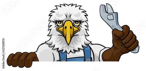 An eagle cartoon animal mascot plumber, mechanic or handyman builder construction maintenance contractor peeking around a sign holding a spanner or wrench
