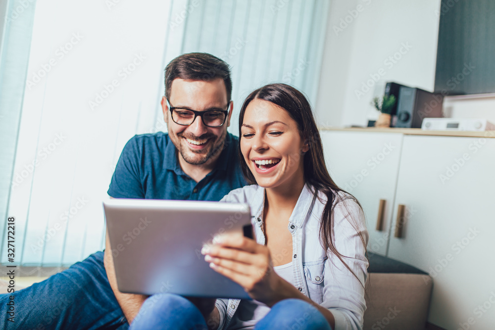 Happy young couple enjoying time online on digital tablet. Happy young couple enjoying time online on digital tablet.