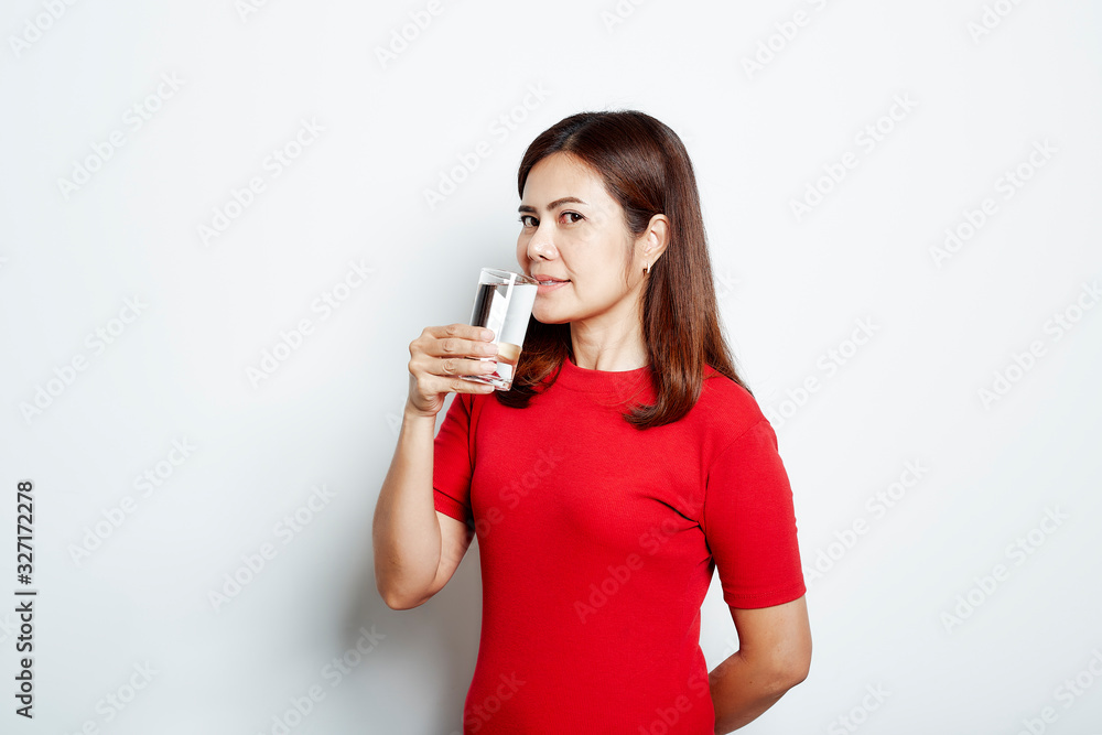 Young beautiful woman drinks water from a glass Young beautiful woman drinks water from a glass