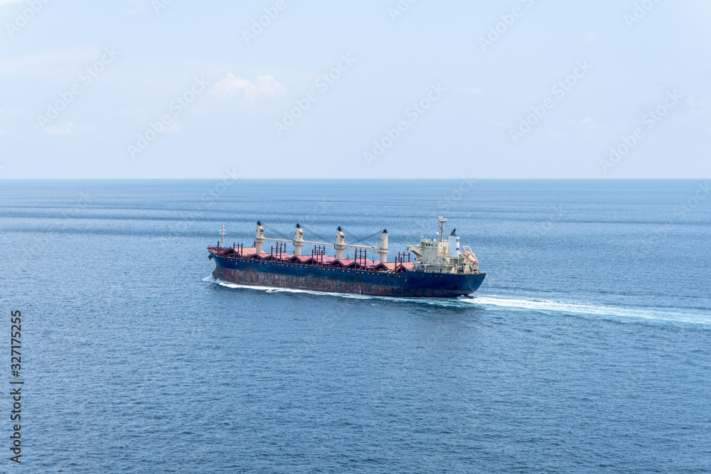 A old bulk carrier or bulker sails in the sea to trade around the world